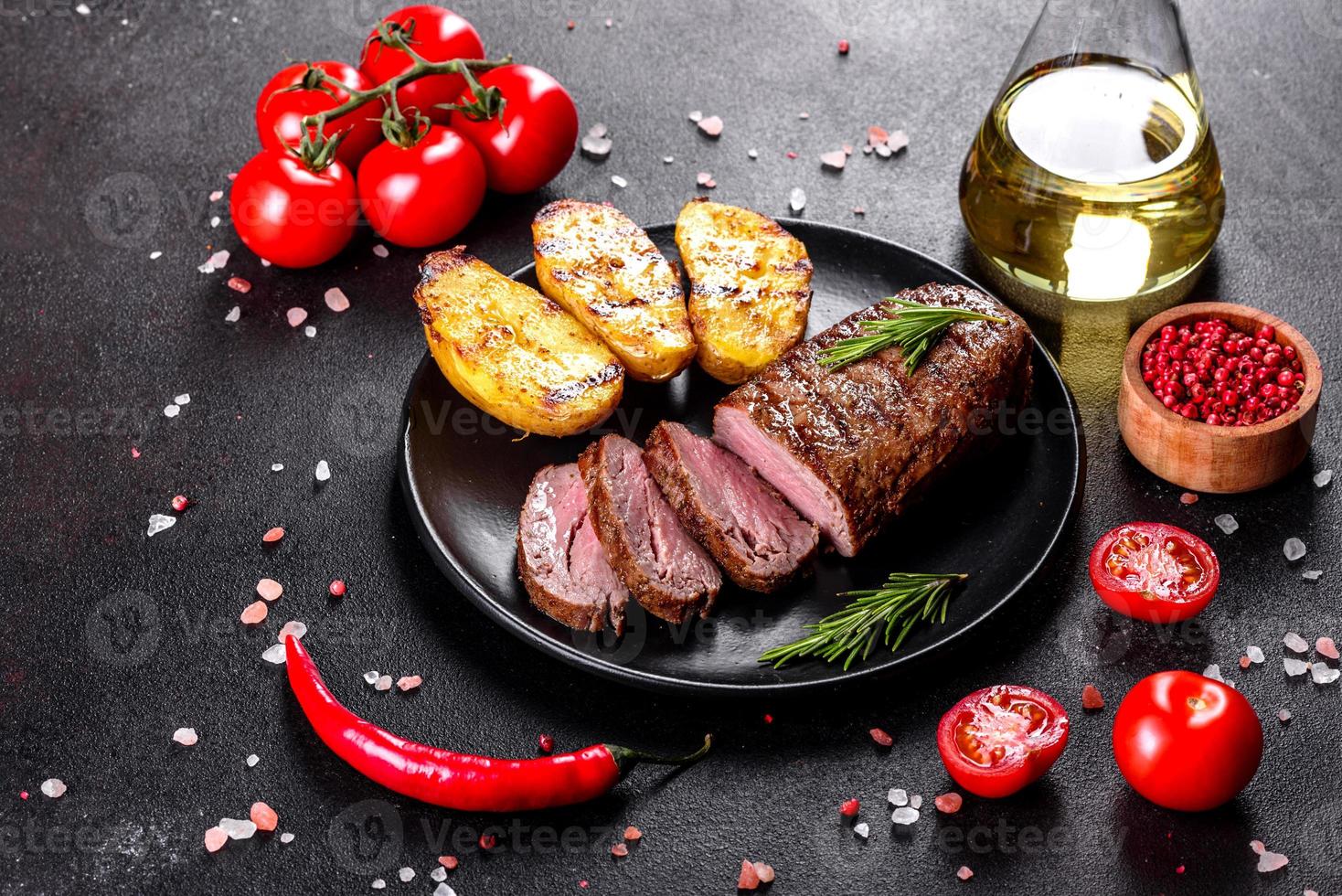 steak de faux-filet avec pommes de terre, oignons et tomates cerises photo