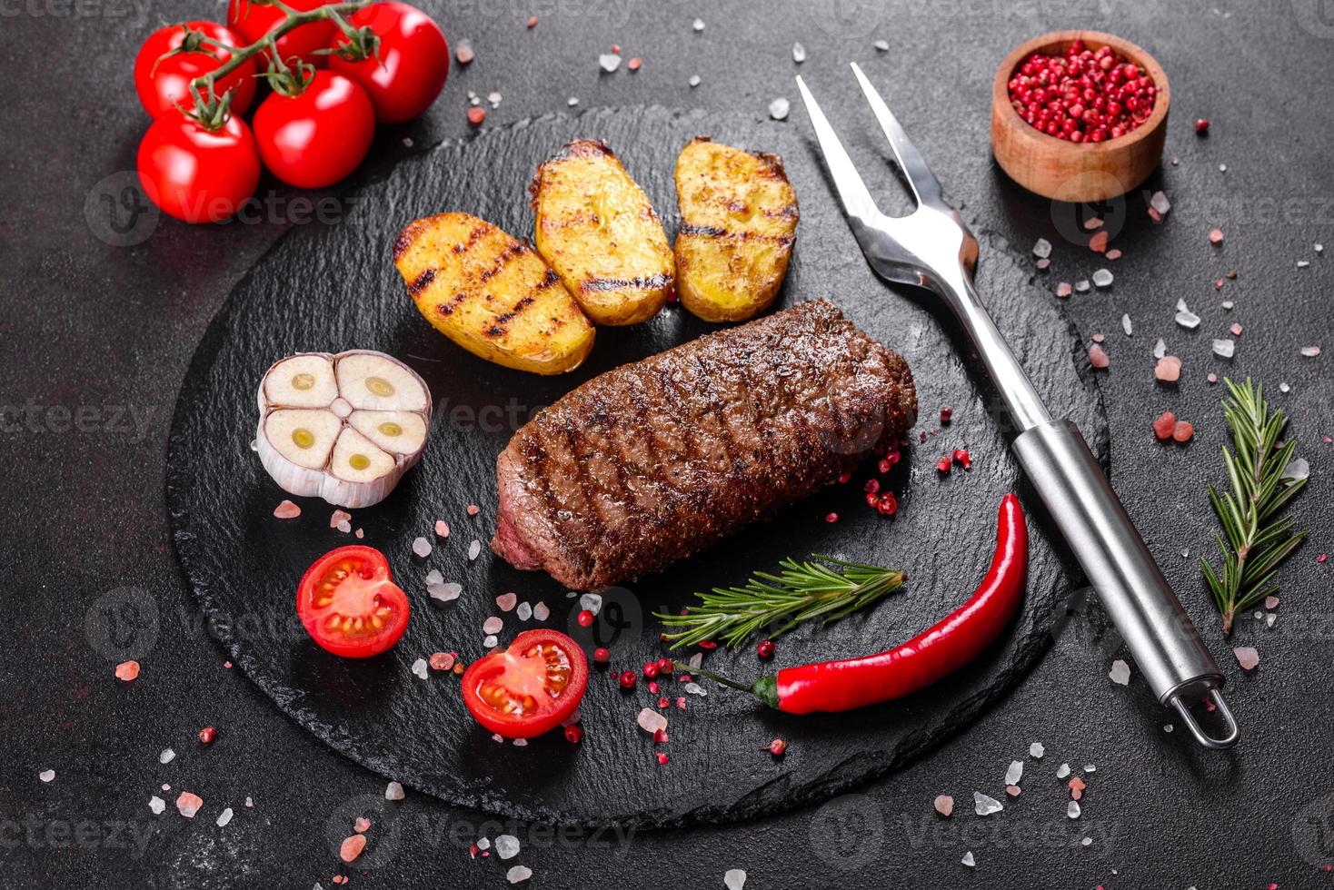 steak de faux-filet avec pommes de terre, oignons et tomates cerises photo