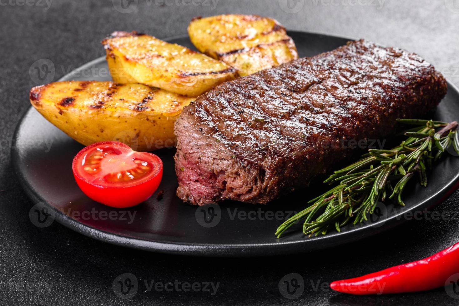 steak de faux-filet avec pommes de terre, oignons et tomates cerises photo