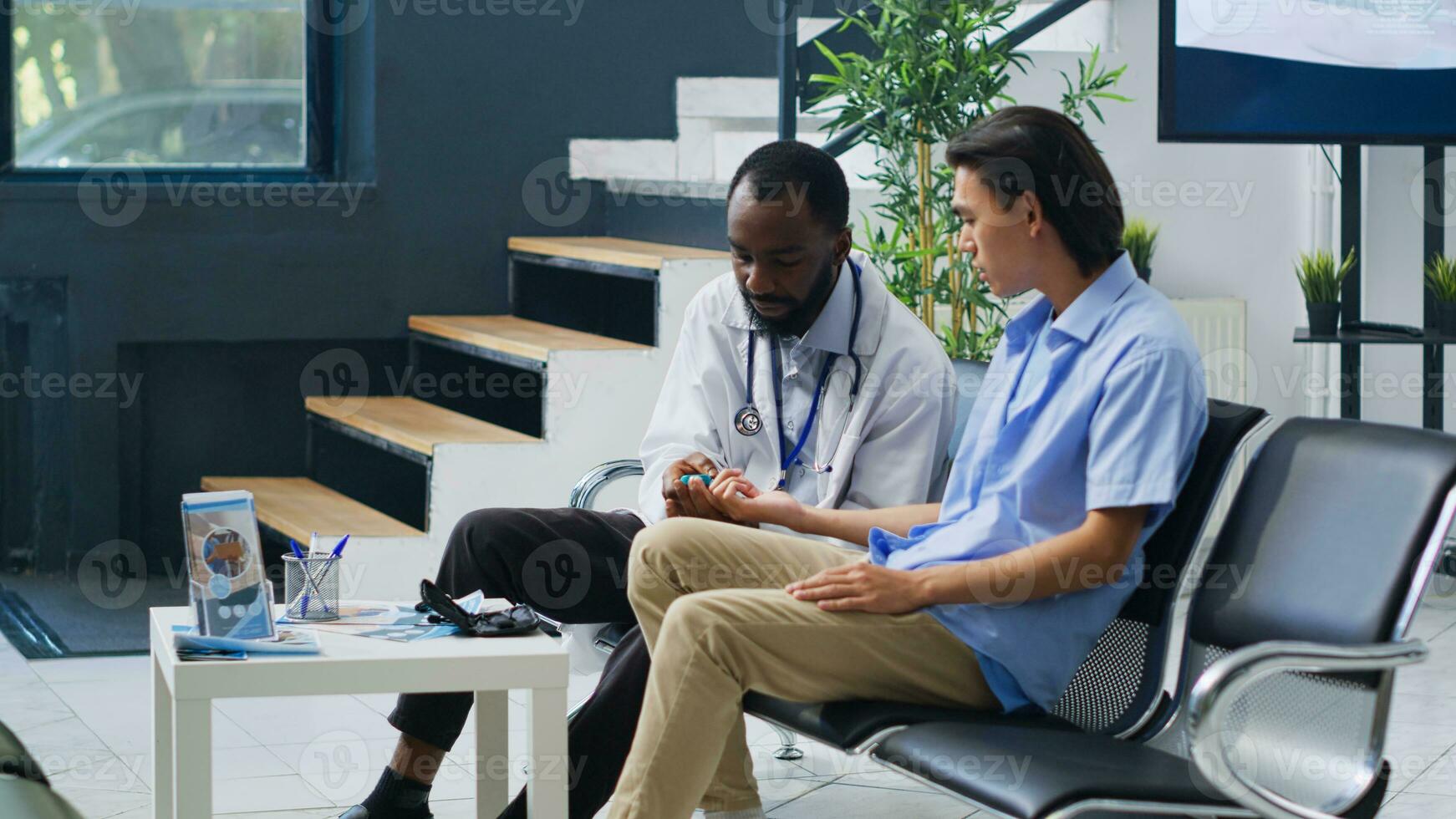 spécialiste en utilisant médical instrument à vérifier asiatique homme du sang goûter, mesure insuline et glucose niveau pendant vérification visite consultation dans hôpital attendre zone. médicament soutien un service photo