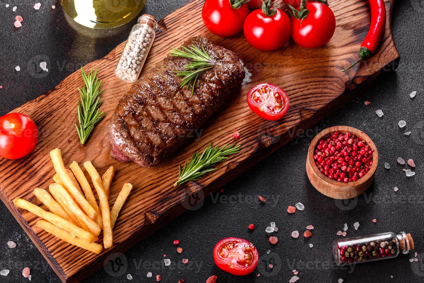 steak de faux-filet avec pommes de terre, oignons et tomates cerises photo