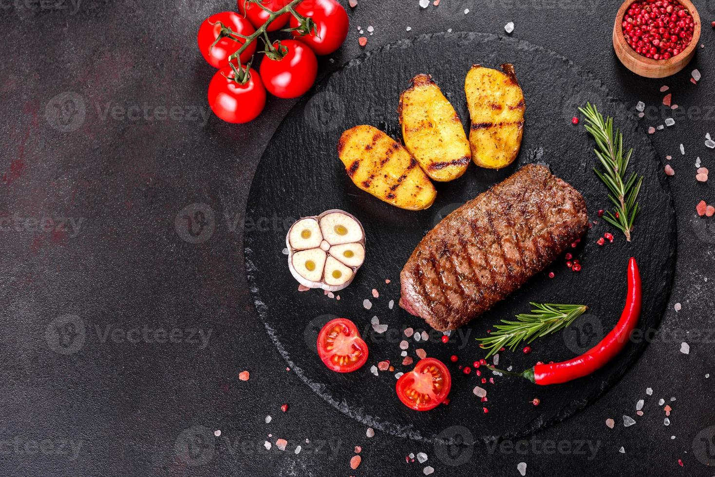 steak de faux-filet avec pommes de terre, oignons et tomates cerises photo