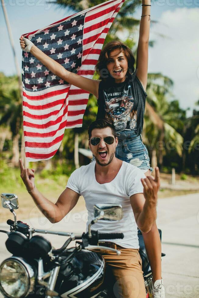 Jeune couple dans aimer, équitation une moto, câlin, passion, gratuit esprit, américain drapeau photo