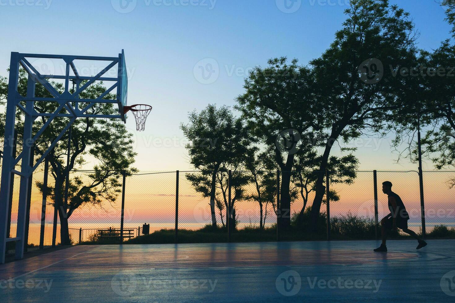 noir homme Faire des sports, en jouant basketball sur lever du soleil, silhouette photo