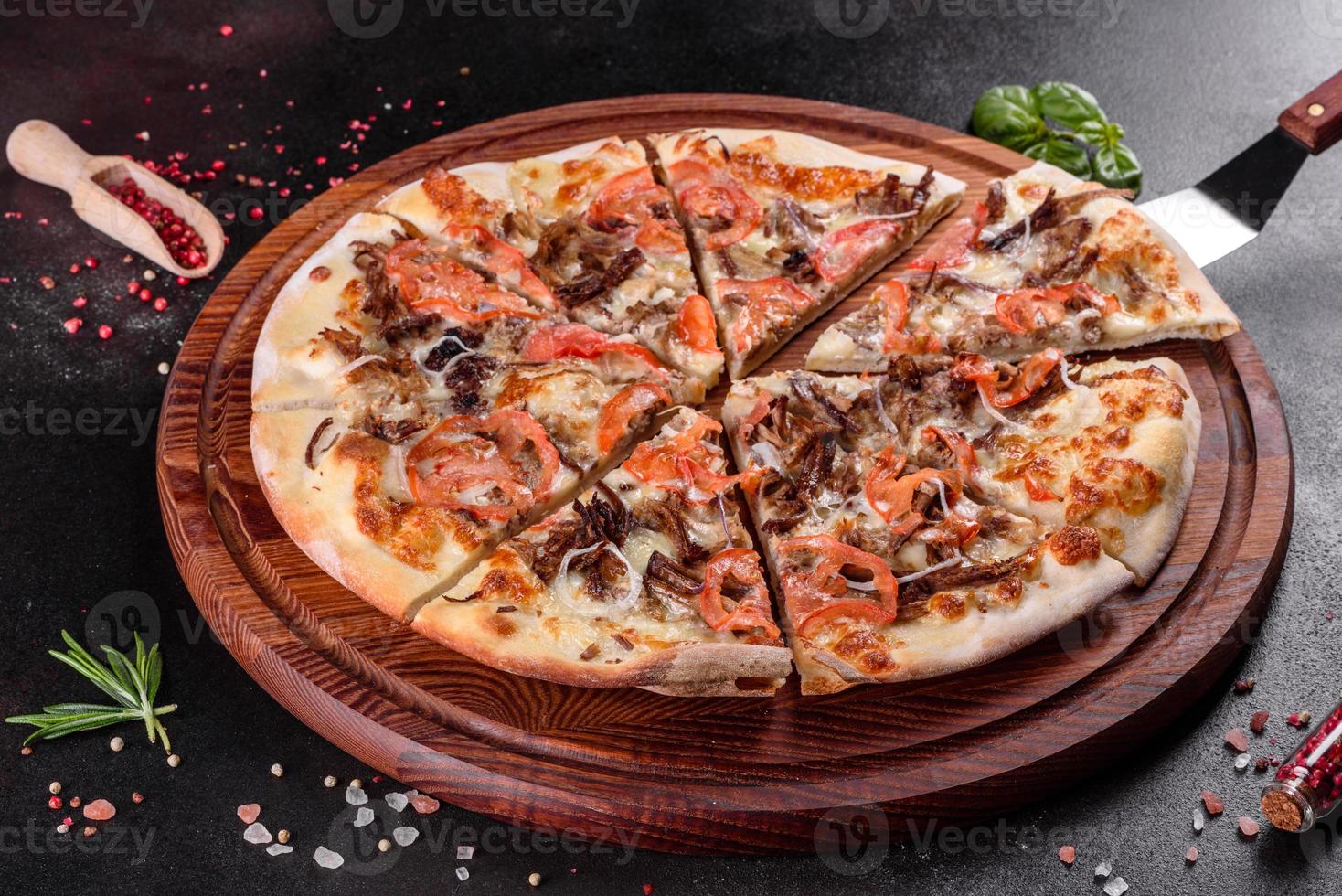 pizza chaude fraîche avec de la viande, des champignons, du fromage et des tomates photo