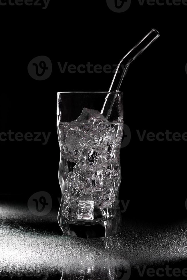 verre d'eau gazeuse boisson gazeuse avec de la glace sur fond noir photo