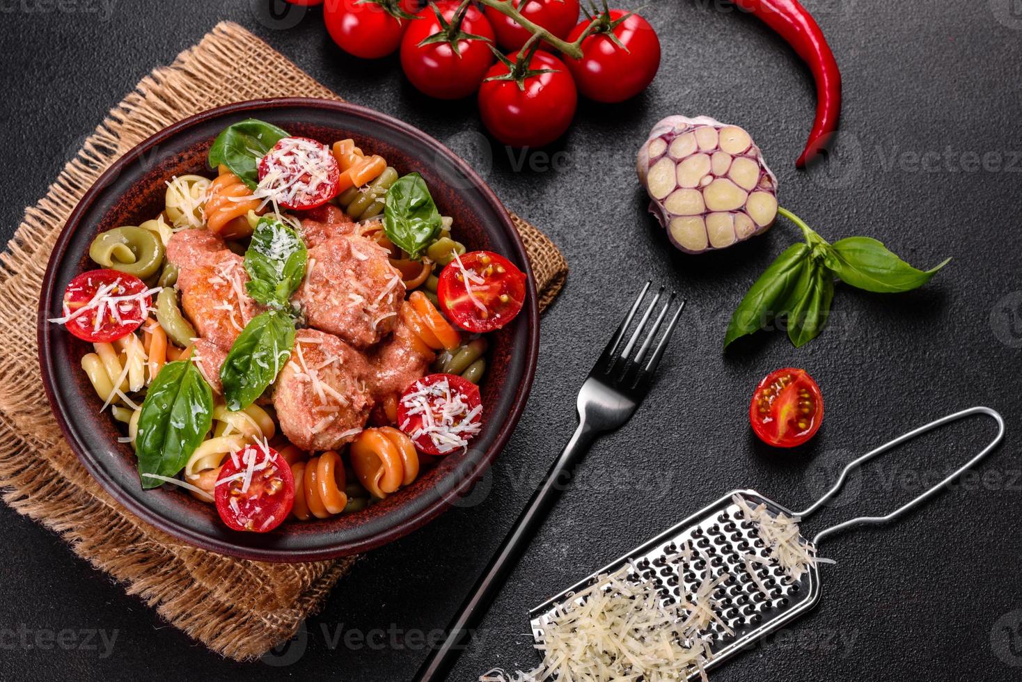 délicieuses pâtes fraîches aux boulettes de viande, sauce, tomates cerises et basilic photo