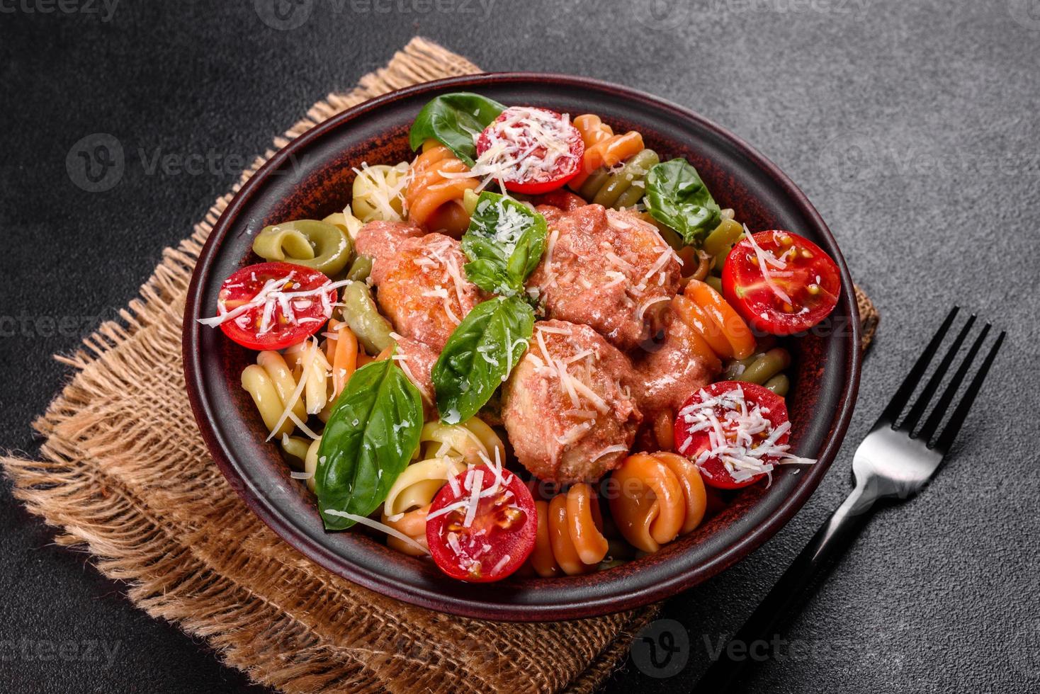 délicieuses pâtes fraîches aux boulettes de viande, sauce, tomates cerises et basilic photo