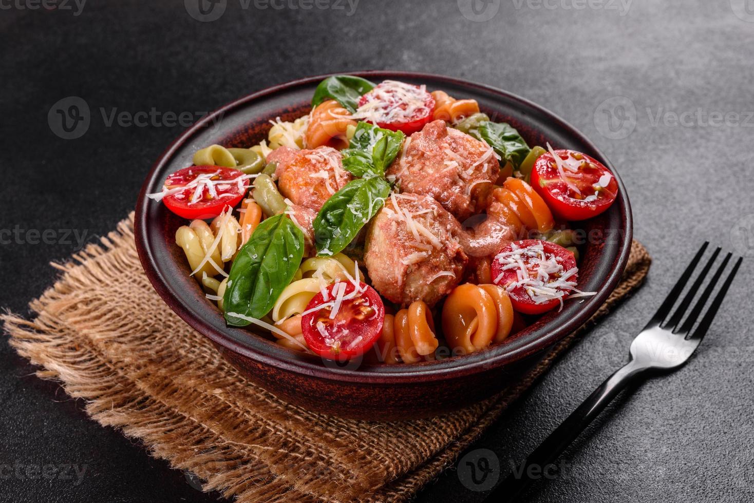 délicieuses pâtes fraîches aux boulettes de viande, sauce, tomates cerises et basilic photo