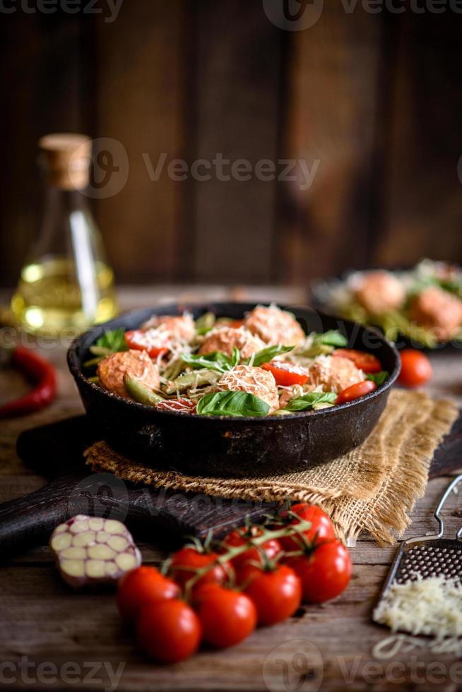 délicieuses pâtes fraîches aux boulettes de viande, sauce, tomates cerises et basilic photo