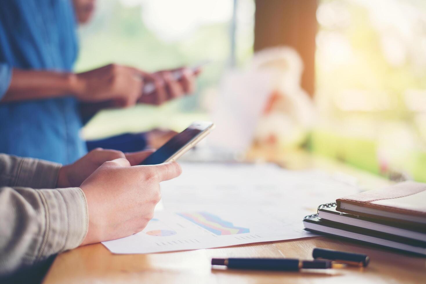 les mains d'une femme d'affaires travaillant sur un téléphone intelligent et des informations commerciales photo