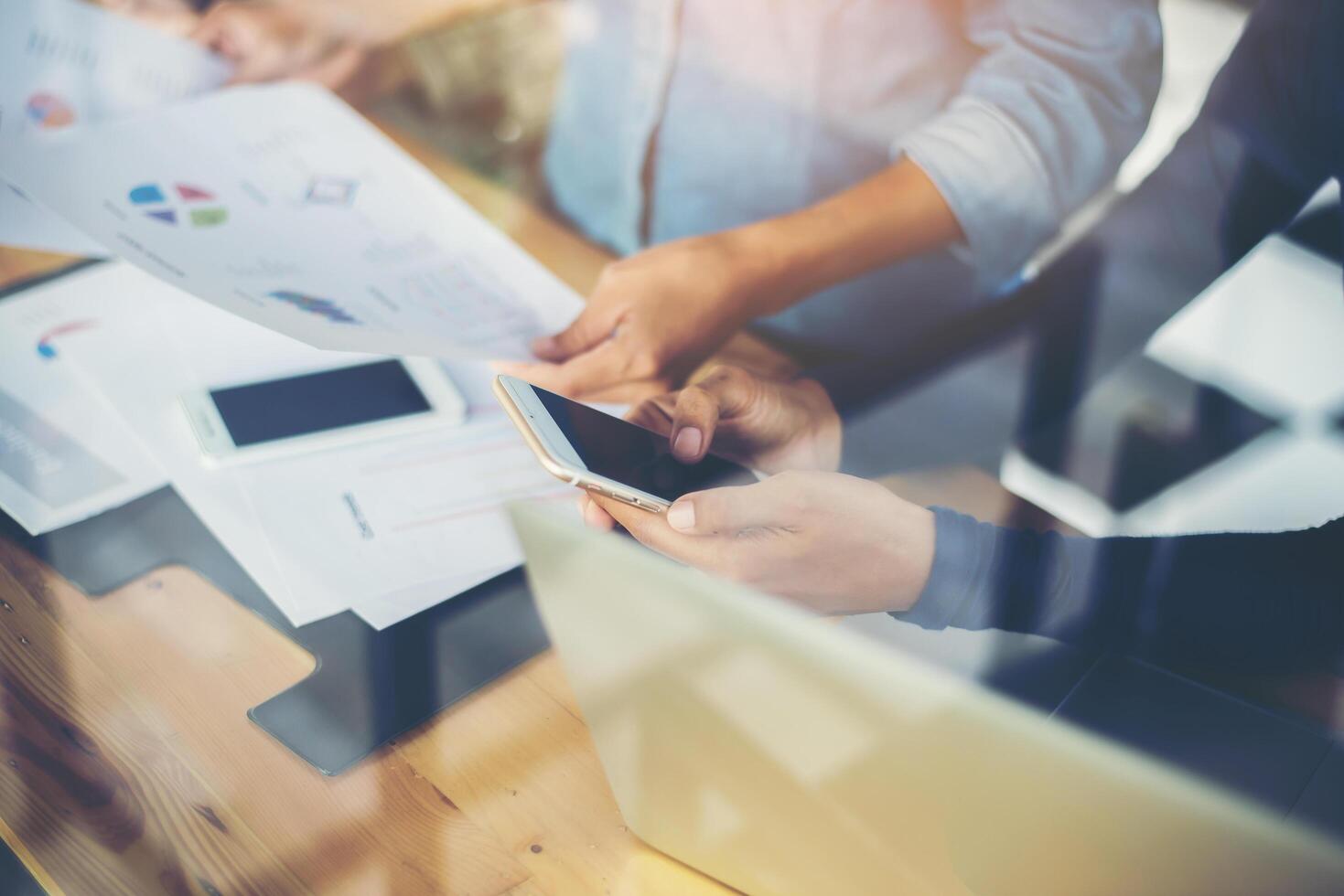 les mains d'une femme d'affaires travaillant sur un téléphone intelligent et des informations commerciales photo