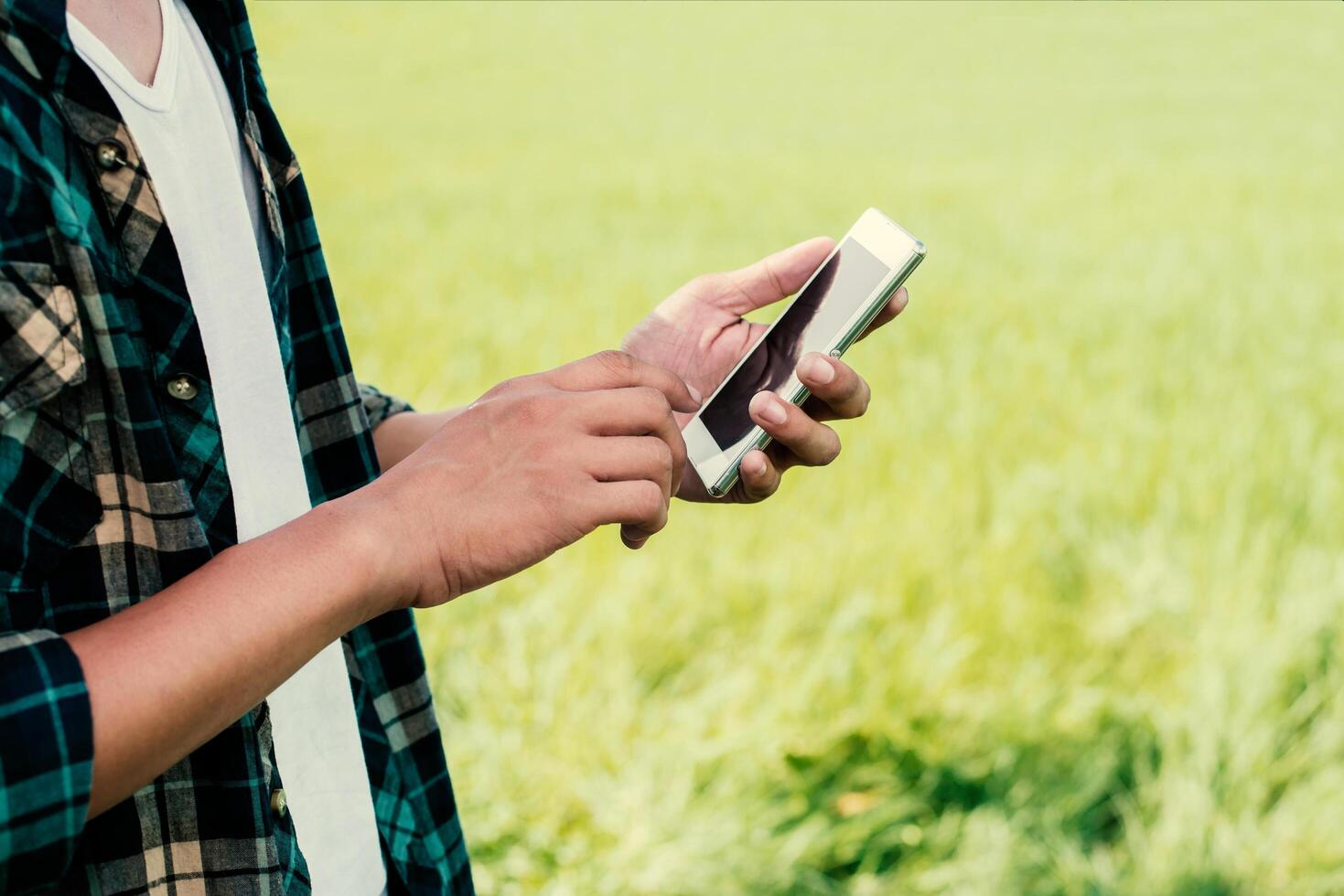 gros plan des mains de l'homme à l'aide de son smartphone en plein air dans le parc. photo