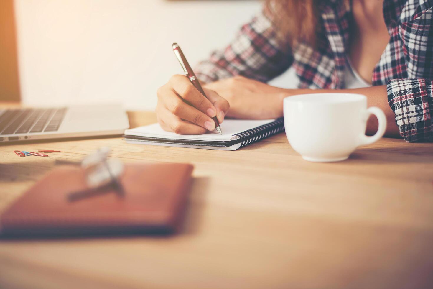 jeune femme hipster écrivant et travaillant sur le lieu de travail. photo