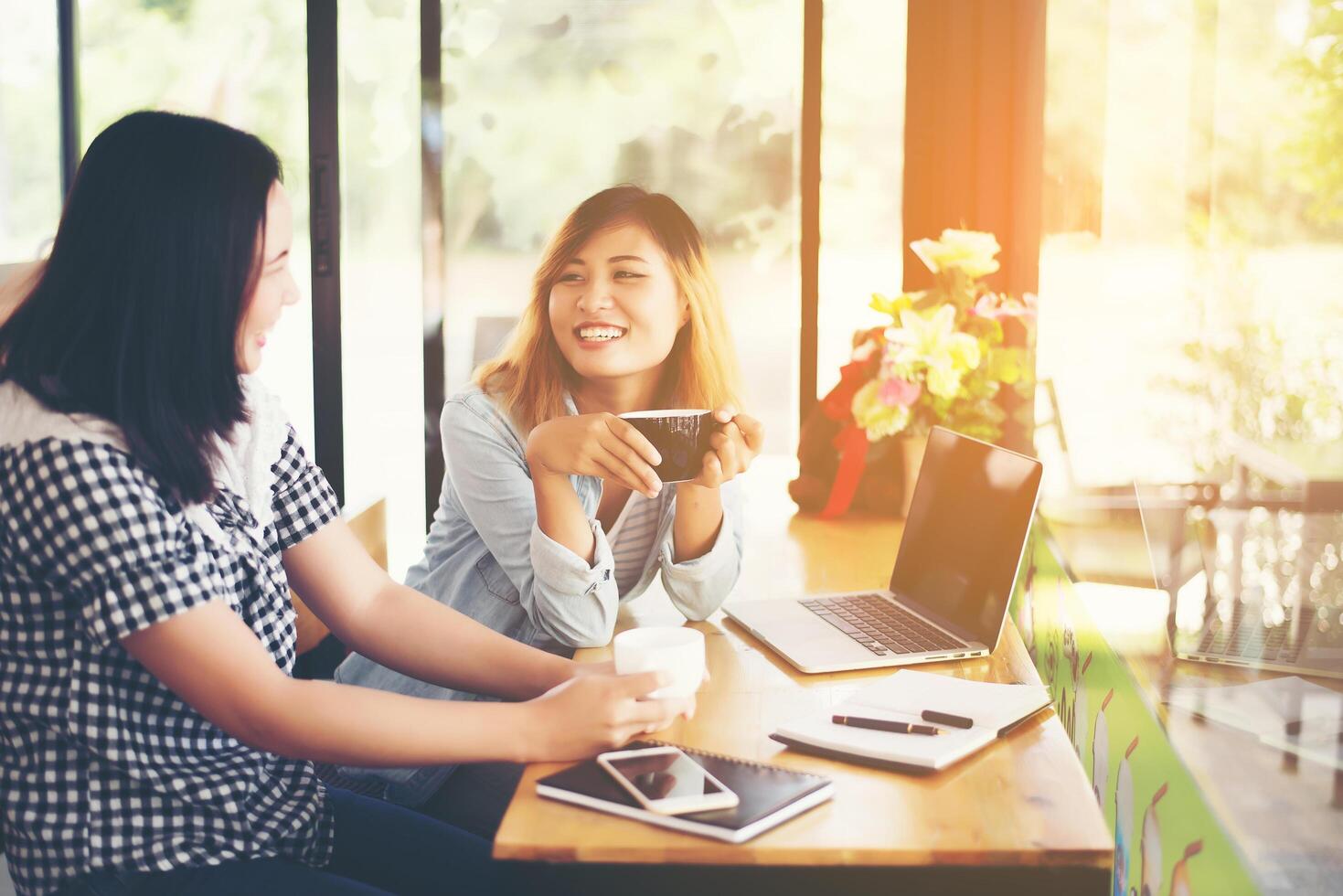 deux belles jeunes femmes discutant dans un café photo