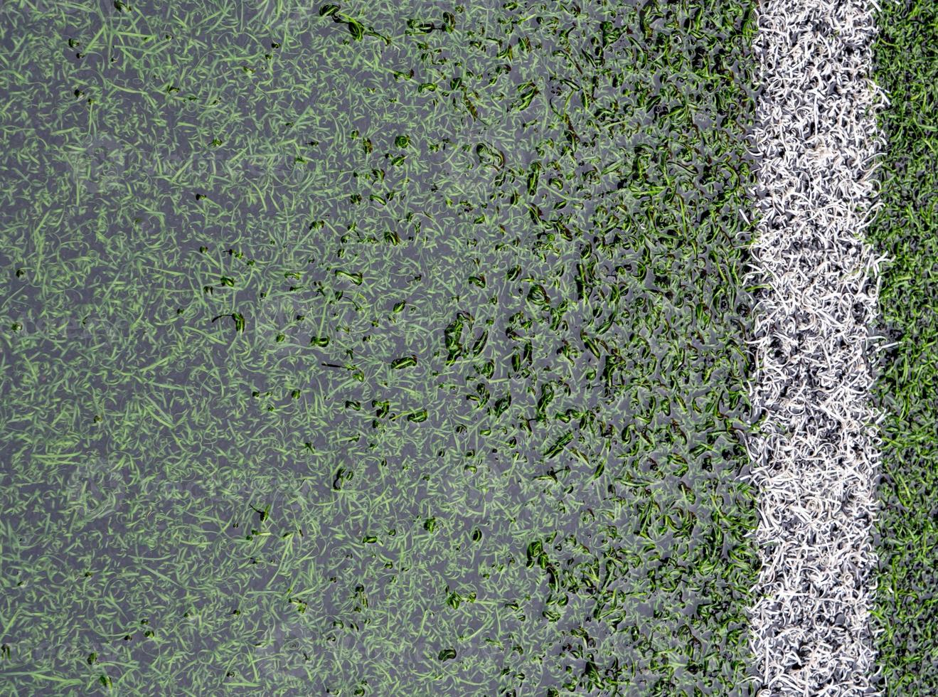 le terrain de football en gazon artificiel est inondé d'eau photo