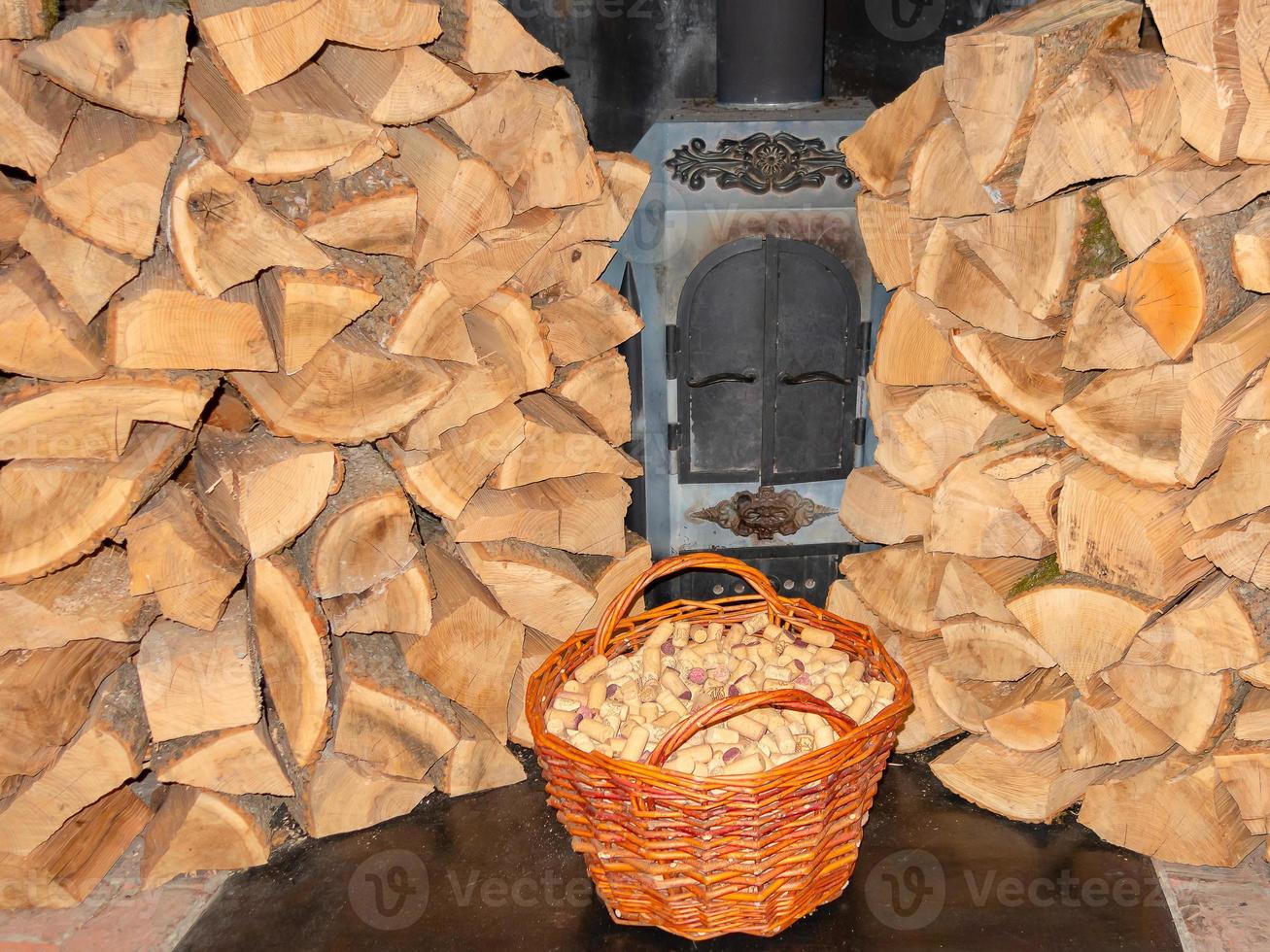 panier avec bouchons à vin près d'un gros tas de bois pour la cheminée photo