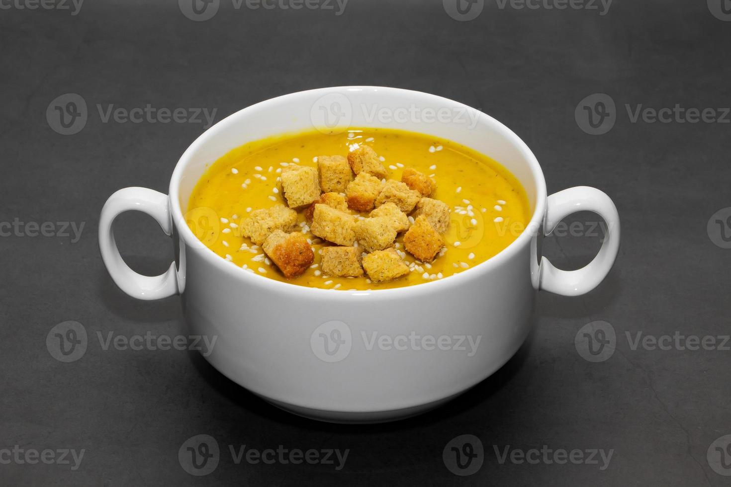 Soupe à la crème de citrouille avec des craquelins sur fond sombre photo