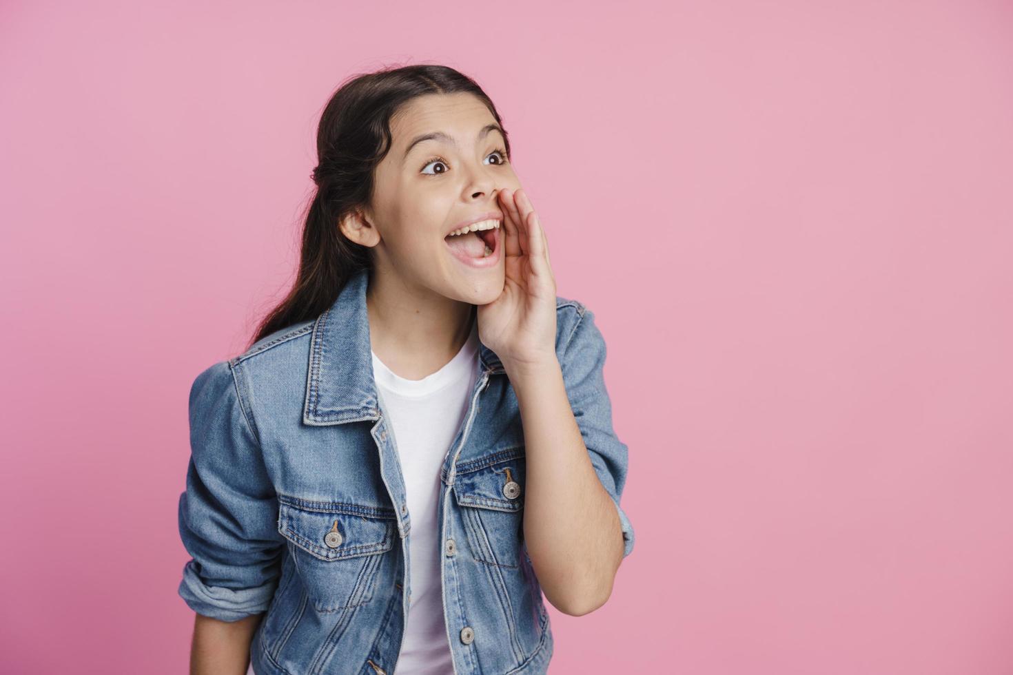 fille tient sa main à sa bouche, appelant quelqu'un photo