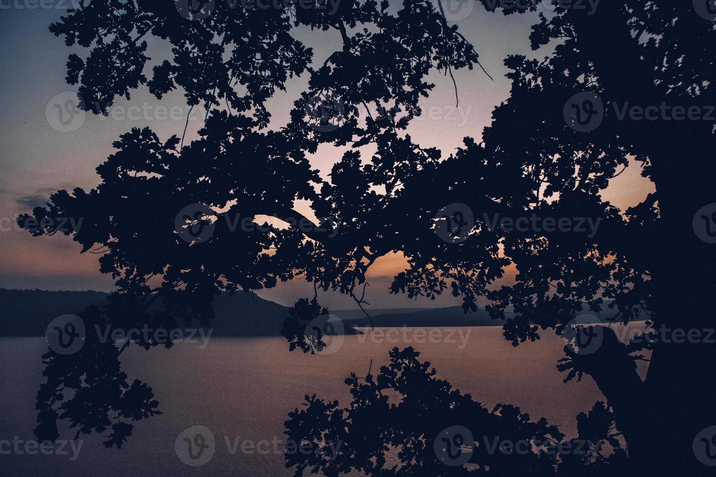 coucher de soleil majestueux dans le paysage de montagnes sur un lac calme photo