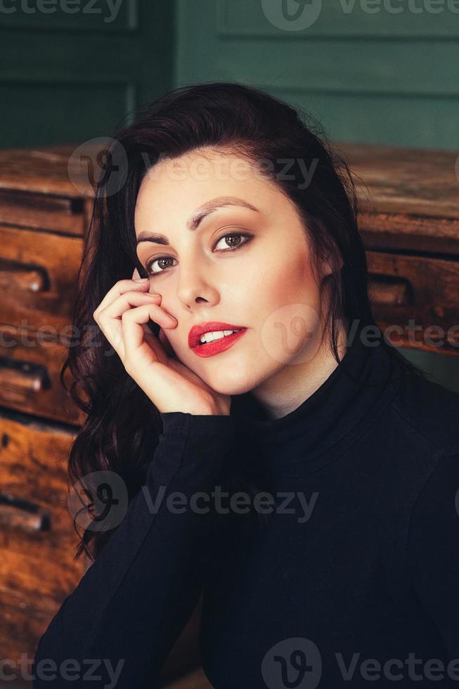 portrait d'une femme brune sur le fond d'une table en bois photo