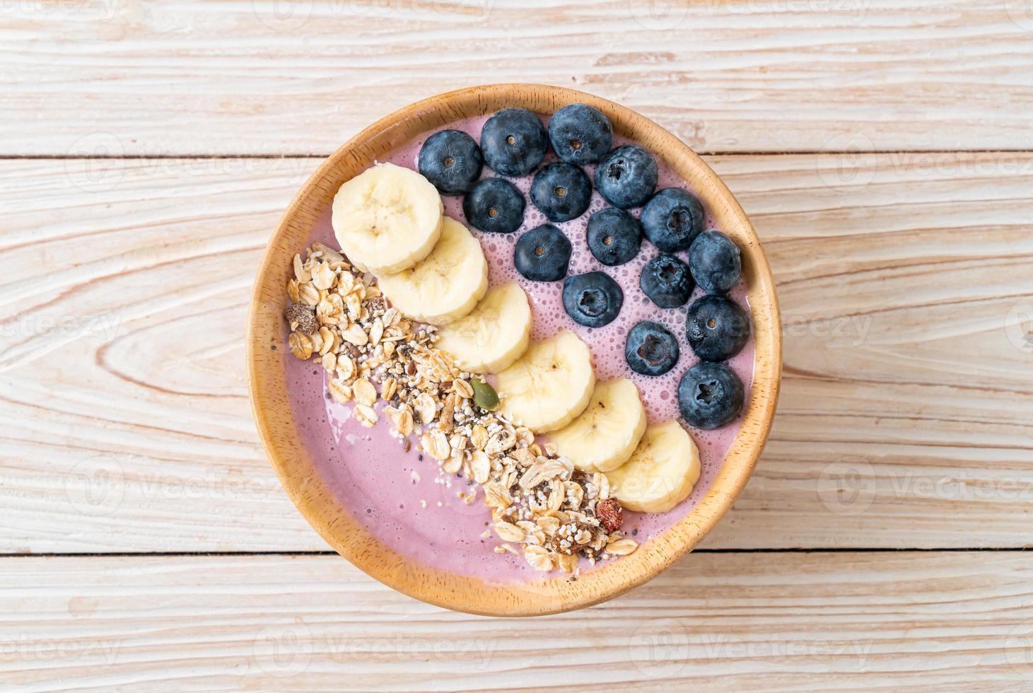 bol de yaourt ou de smoothie au yaourt avec baies bleues, banane et granola - style alimentaire sain photo