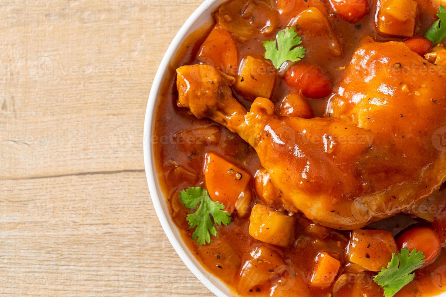 ragoût de poulet maison avec tomates, oignons, carottes et pommes de terre sur assiette photo