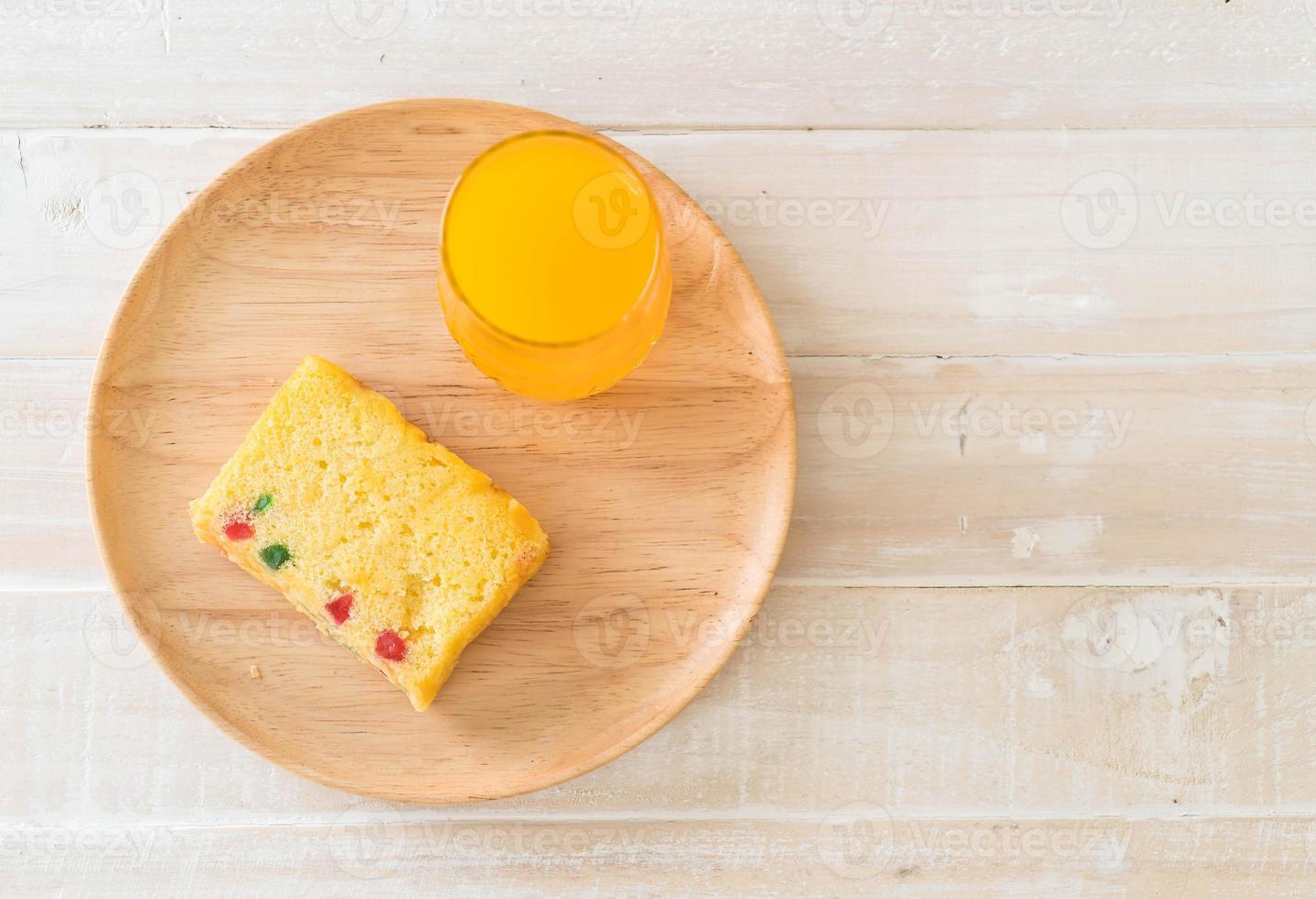 gâteau aux fruits sur plaque de bois avec jus d'orange photo