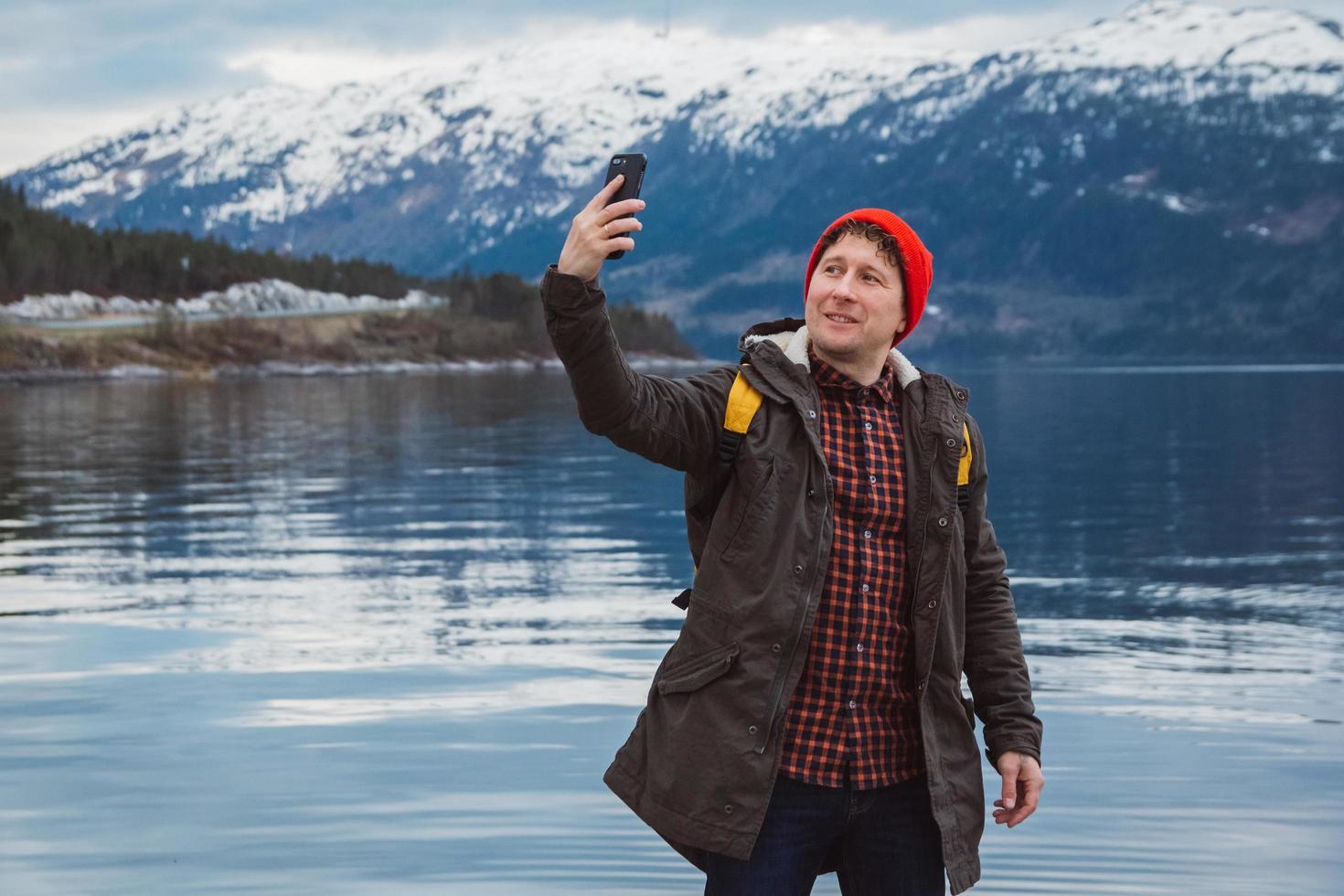 homme voyageur prenant une photo d'autoportrait avec un smartphone