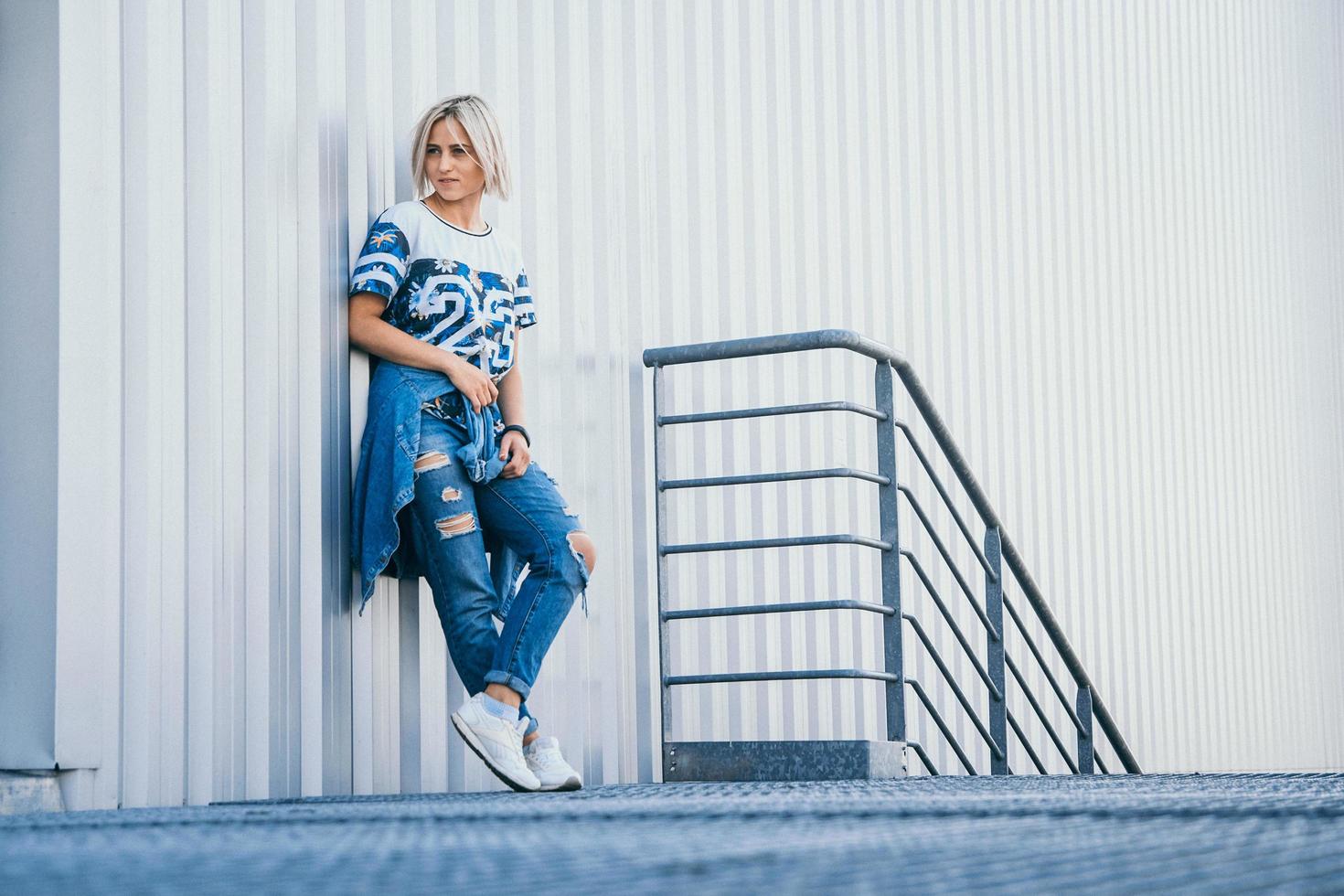 belle fille aux cheveux blancs courts vêtue de jeans dans un style urbain photo