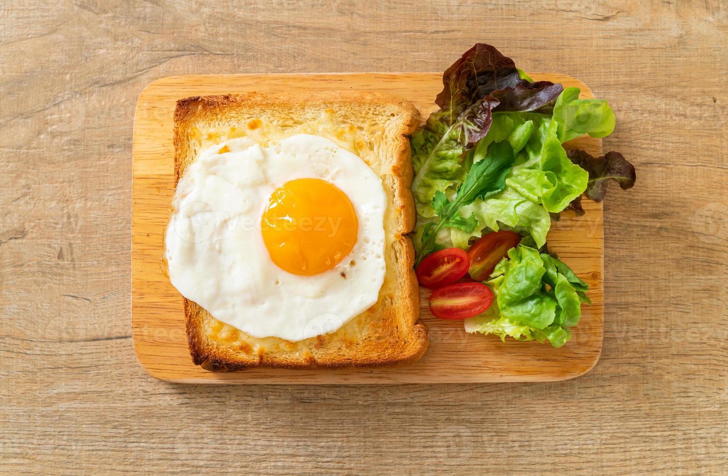 pain maison grillé avec du fromage et un œuf au plat sur le dessus avec une salade de légumes pour le petit-déjeuner photo