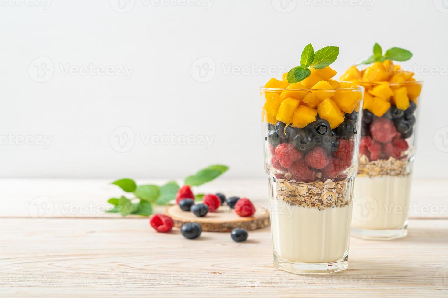 mangue, framboise et myrtille maison avec yaourt et granola - style alimentaire sain photo