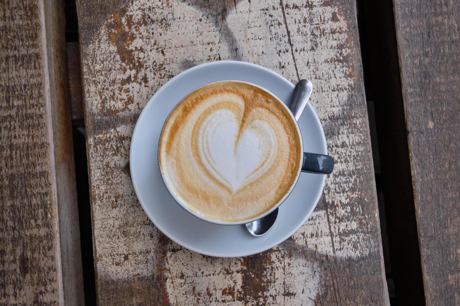 vue de dessus d'une tasse de cappuccino avec mousse coeur sur une surface en bois photo