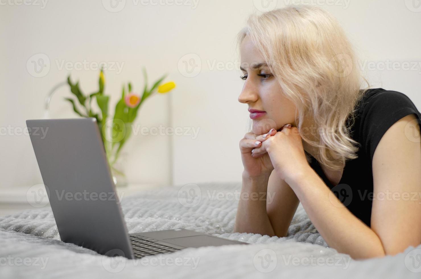 la fille regarde une série télévisée sur un ordinateur portable. photo