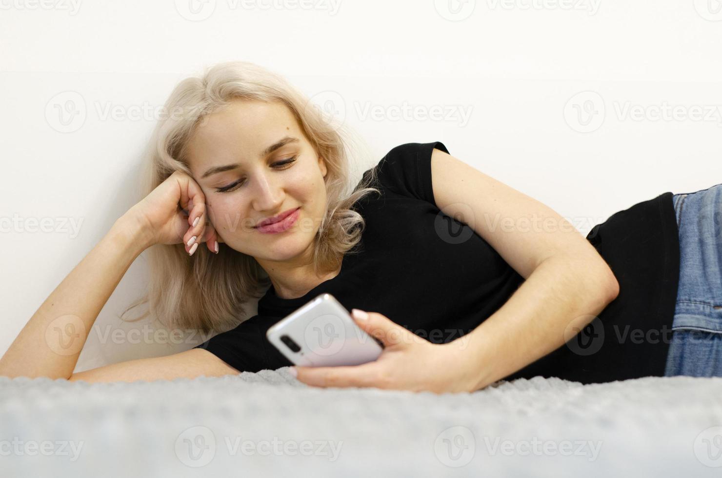 la fille lit la bonne nouvelle au téléphone. réseaux sociaux. photo