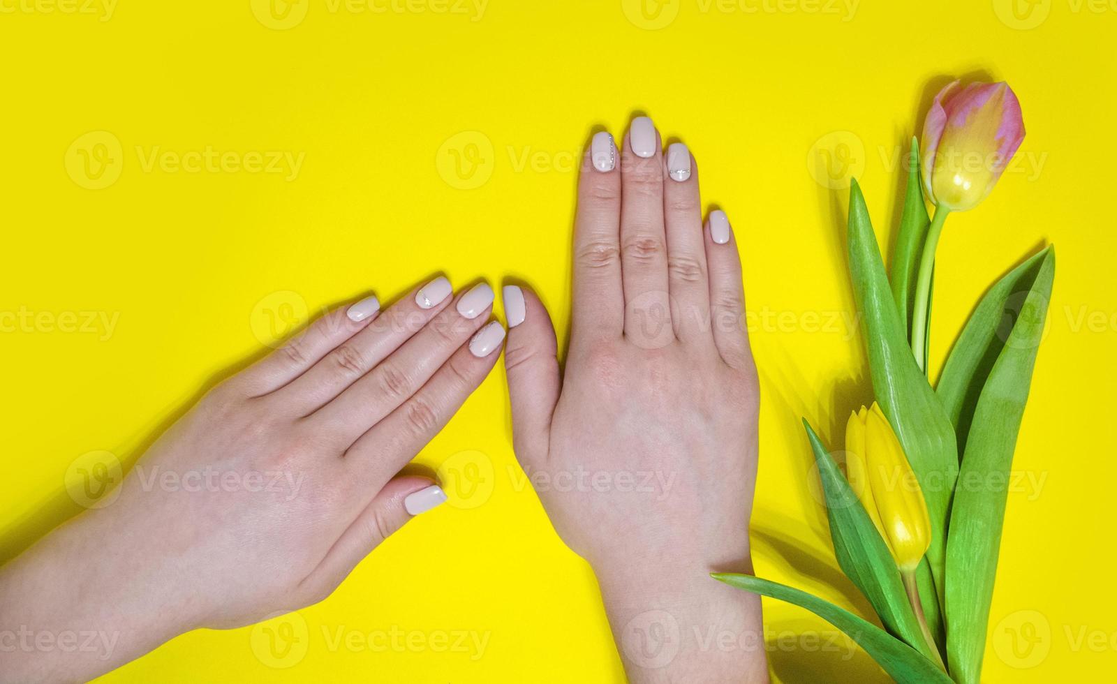 manucure féminine sur fond clair. jaune photo