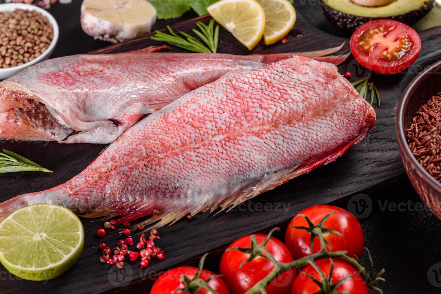 filet cru de perche de mer rouge préparé pour la cuisson avec des épices et des herbes photo