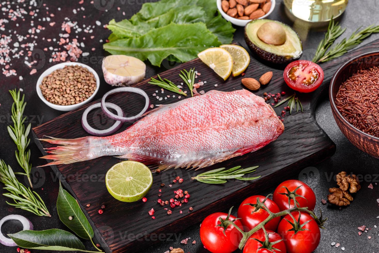 filet cru de perche de mer rouge préparé pour la cuisson avec des épices et des herbes photo