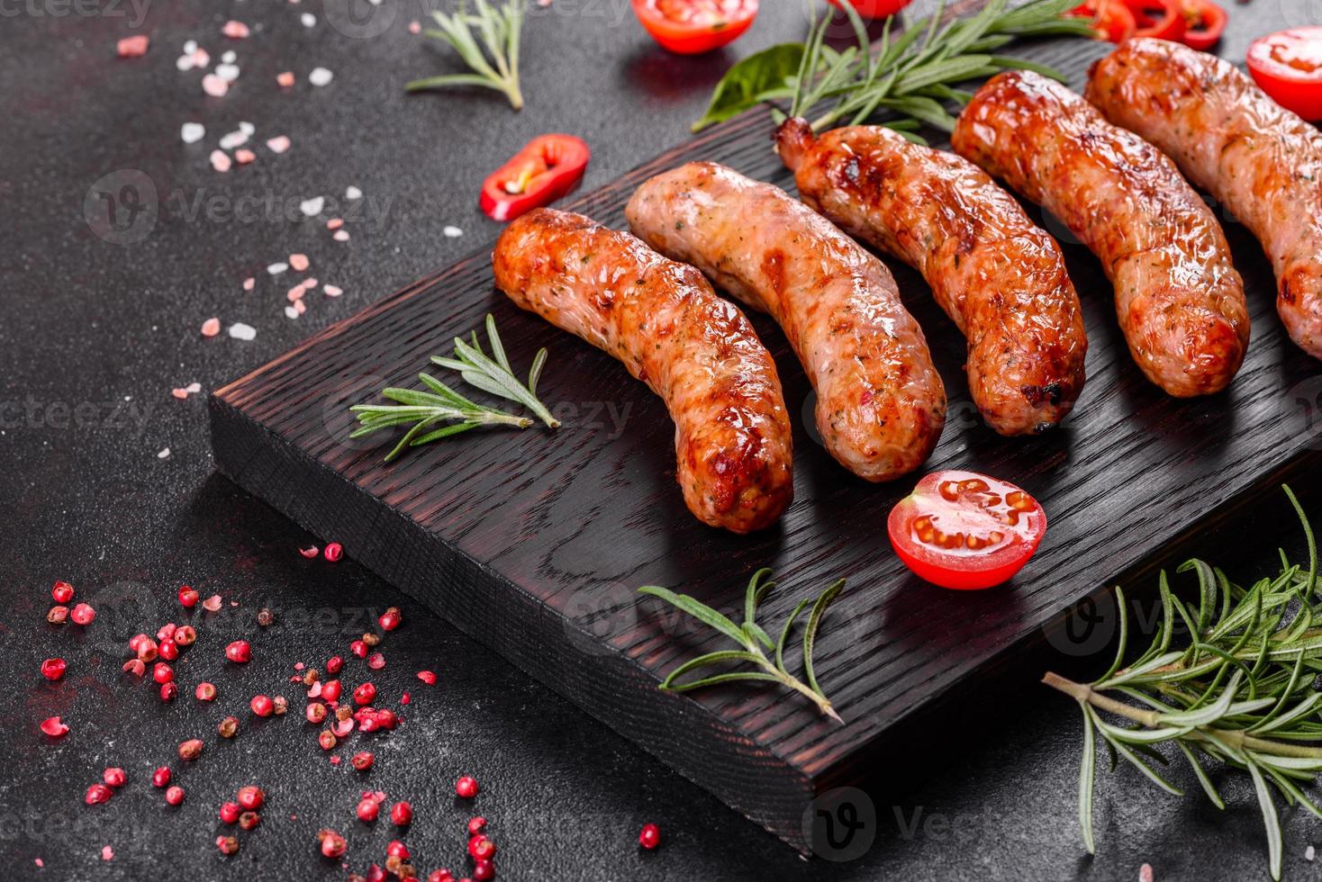 saucisses grillées aux légumes et épices sur fond noir photo