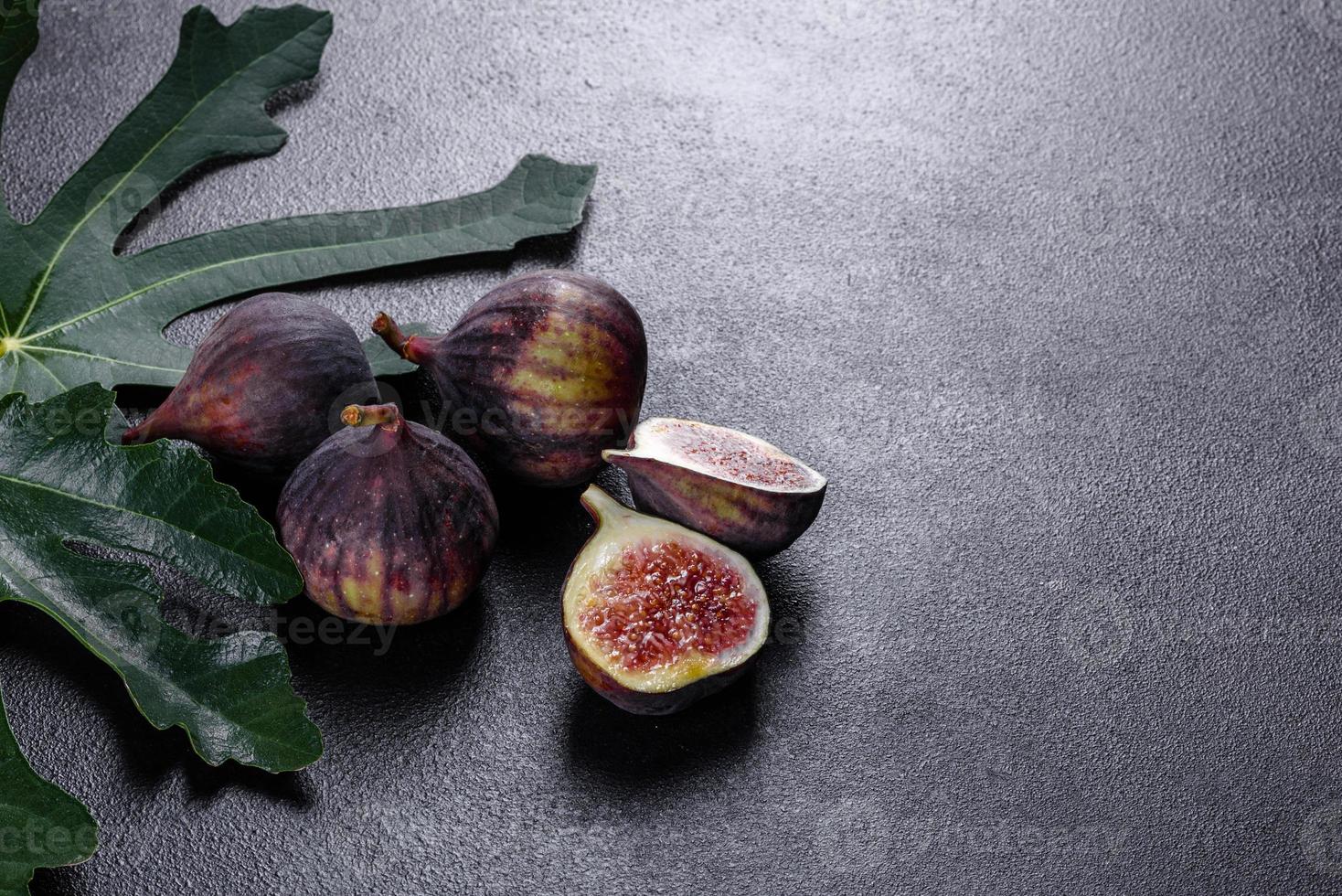 figues mûres fraîches sur un fond de béton foncé. récolte de figues photo