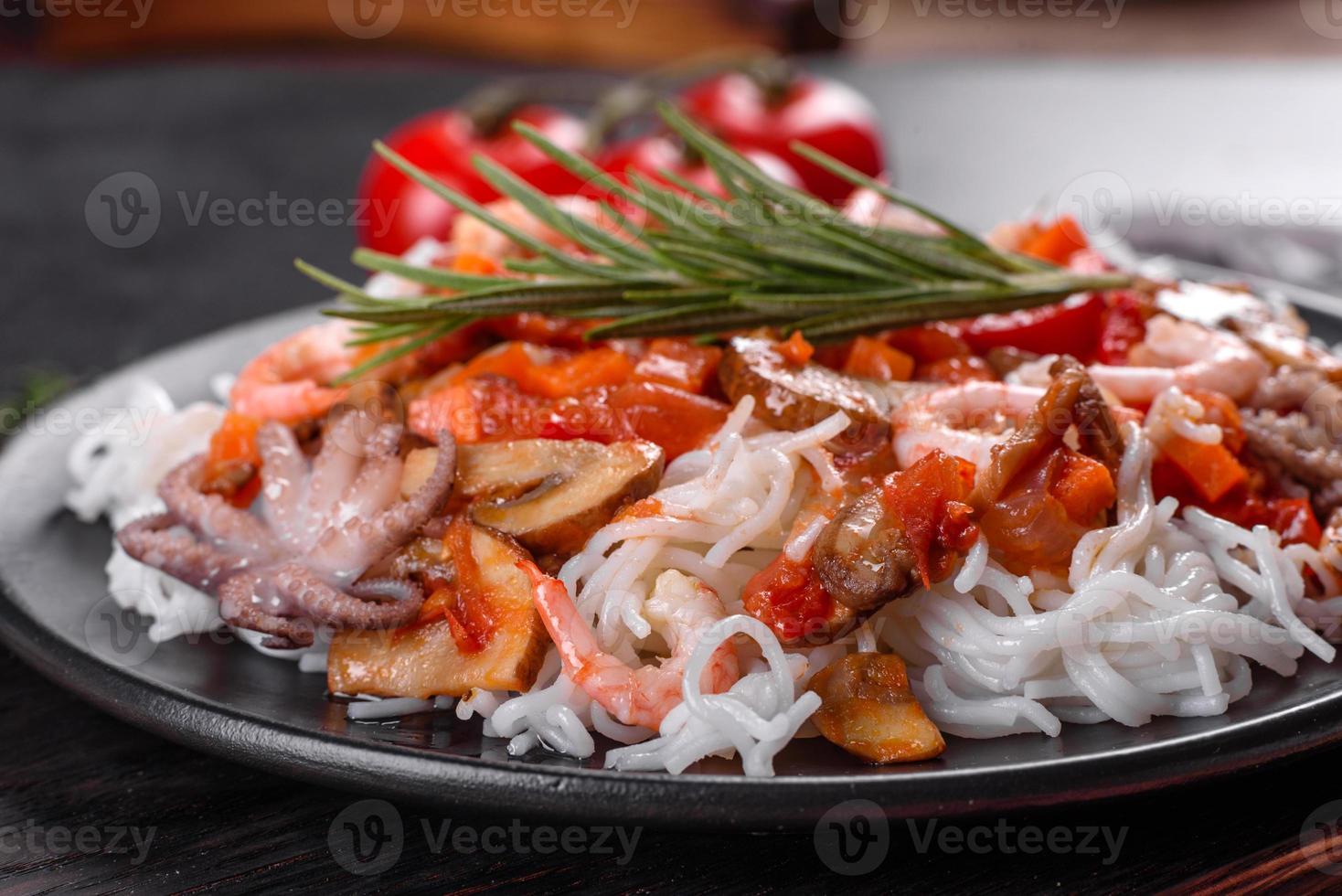 savoureuses nouilles de riz avec tomate, poivron rouge, champignons et fruits de mer photo