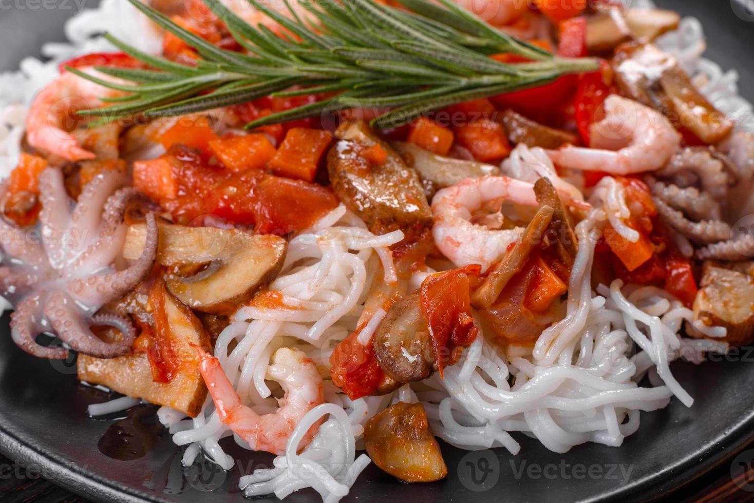 savoureuses nouilles de riz avec tomate, poivron rouge, champignons et fruits de mer photo