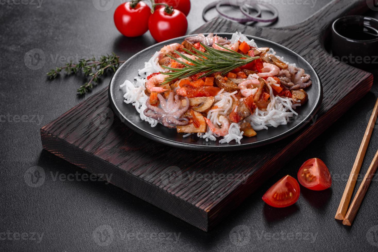 savoureuses nouilles de riz avec tomate, poivron rouge, champignons et fruits de mer photo