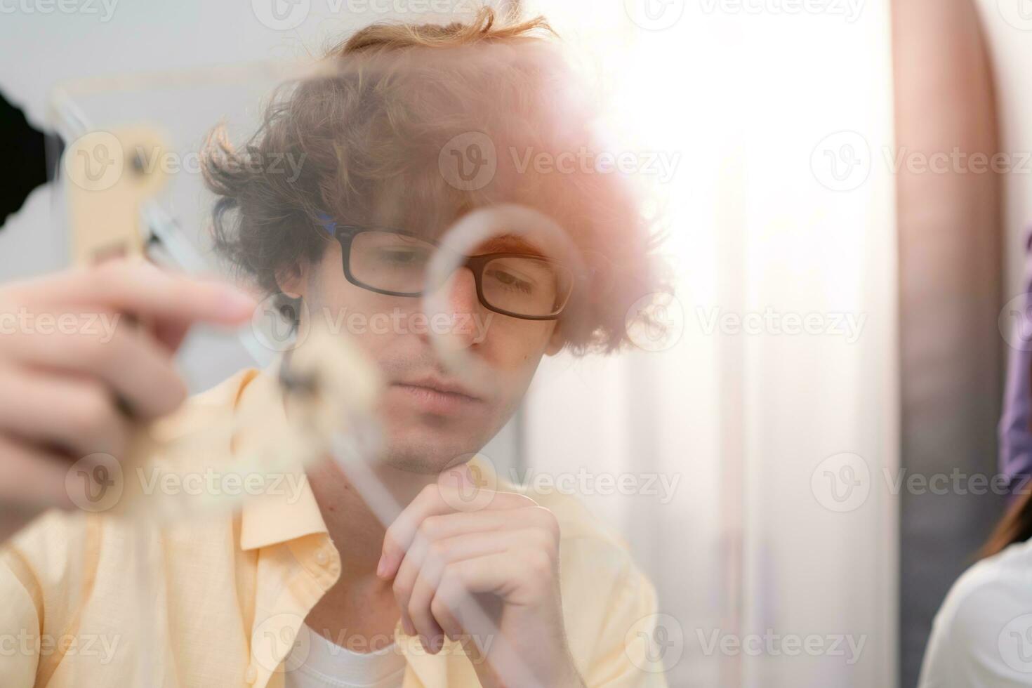 une Jeune Masculin architecte et designer est conception une vert Accueil bâtiment cette prend avantage de Naturel énergie tel comme vent et lumière du soleil. photo