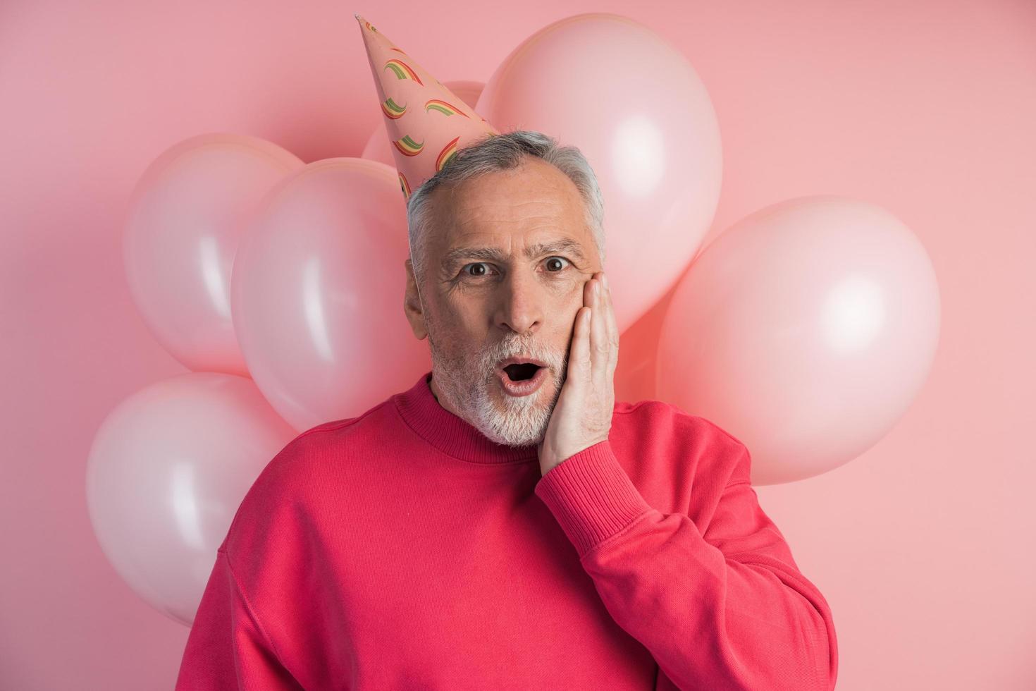 homme surpris avec un chapeau de fête sur la tête souriant photo