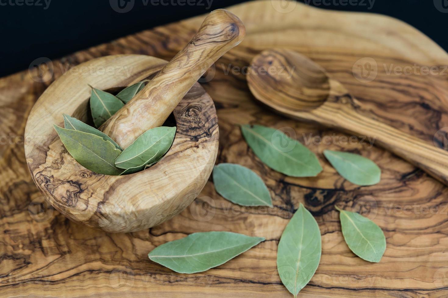 feuilles de laurier et baies de genièvre sur bois d'olivier photo