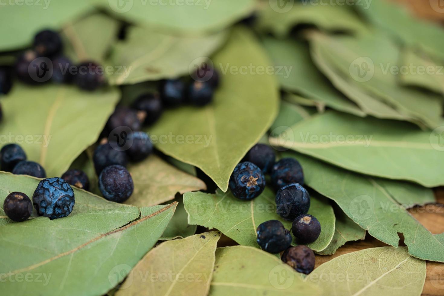 feuilles de laurier et baies de genièvre sur bois d'olivier photo