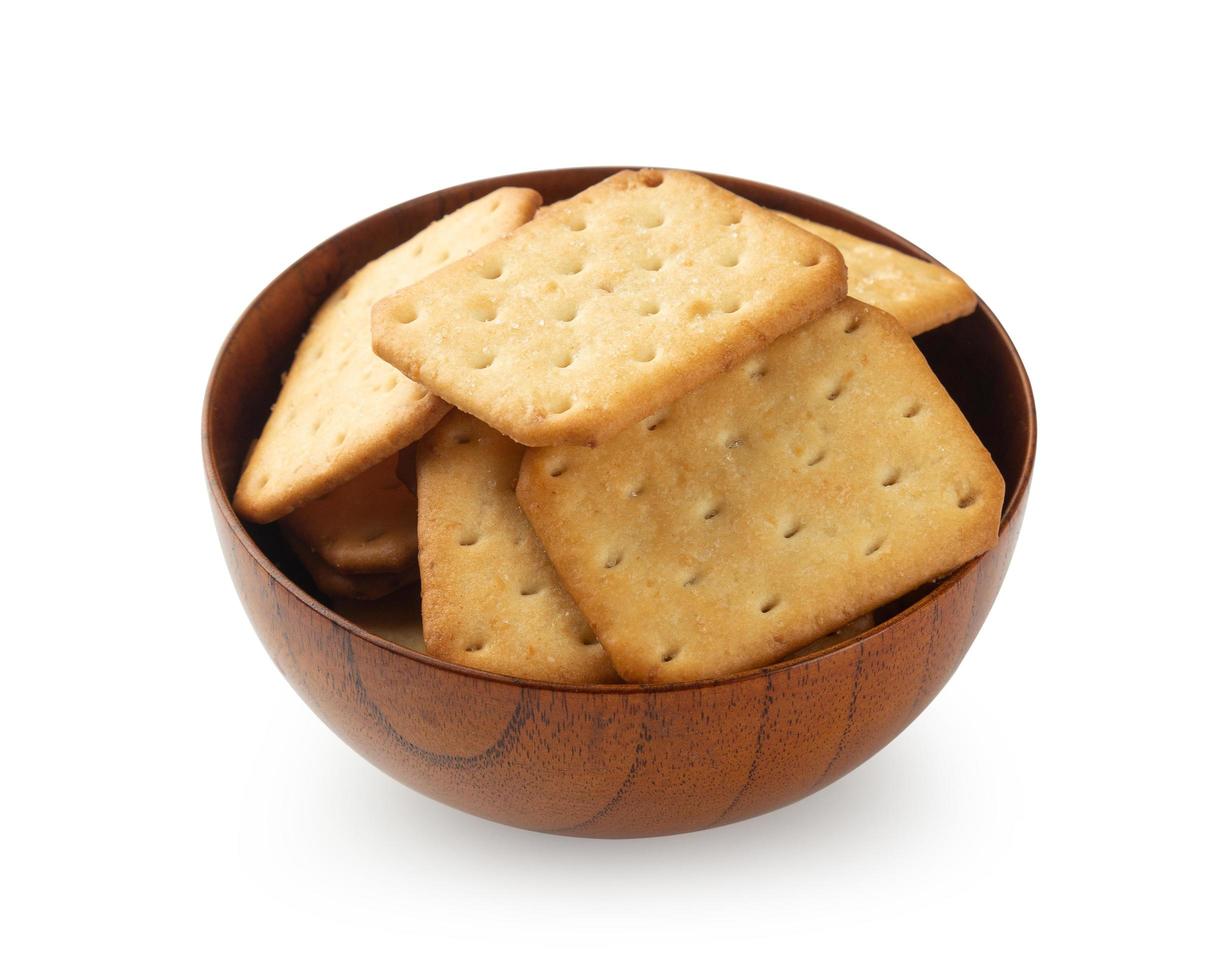 Biscuits craquelins dans un bol en bois isolé sur fond blanc photo