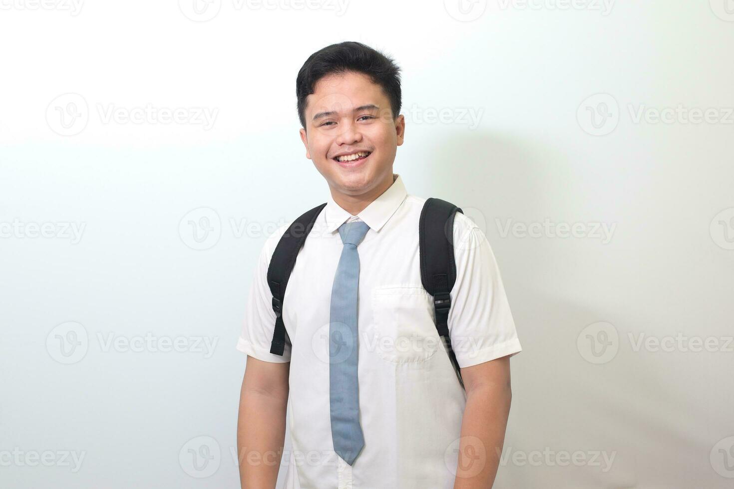 indonésien Sénior haute école étudiant portant blanc chemise uniforme avec gris attacher souriant et à la recherche à caméra. isolé image sur blanc Contexte photo