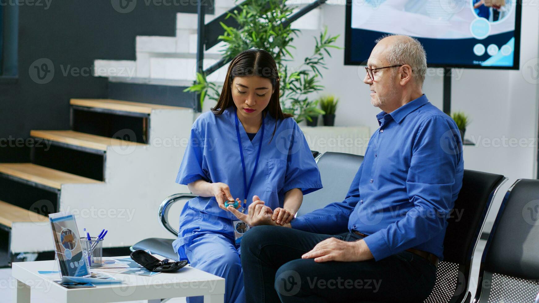 asiatique infirmière mesure sucre niveau avec du sang échantillon à faire insuline tester avec glucomètre pour personnes âgées patient avec Diabète pendant examen. assistant vérification glucose dans hôpital attendre pièce photo